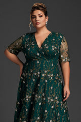 Plus-size model wearing a green floral embroidered dress with short sheer sleeves and a wrap-style bodice, perfect for formal occasions.