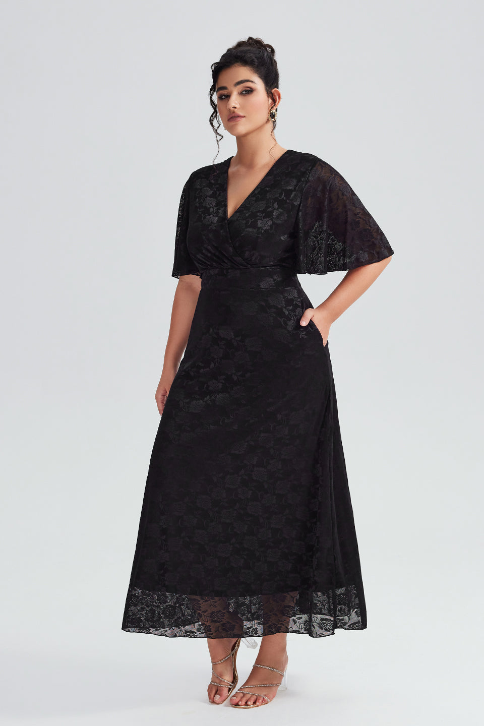 Side view of plus-size black lace maxi dress featuring a V-neckline and flutter sleeves, elegant for formal occasions