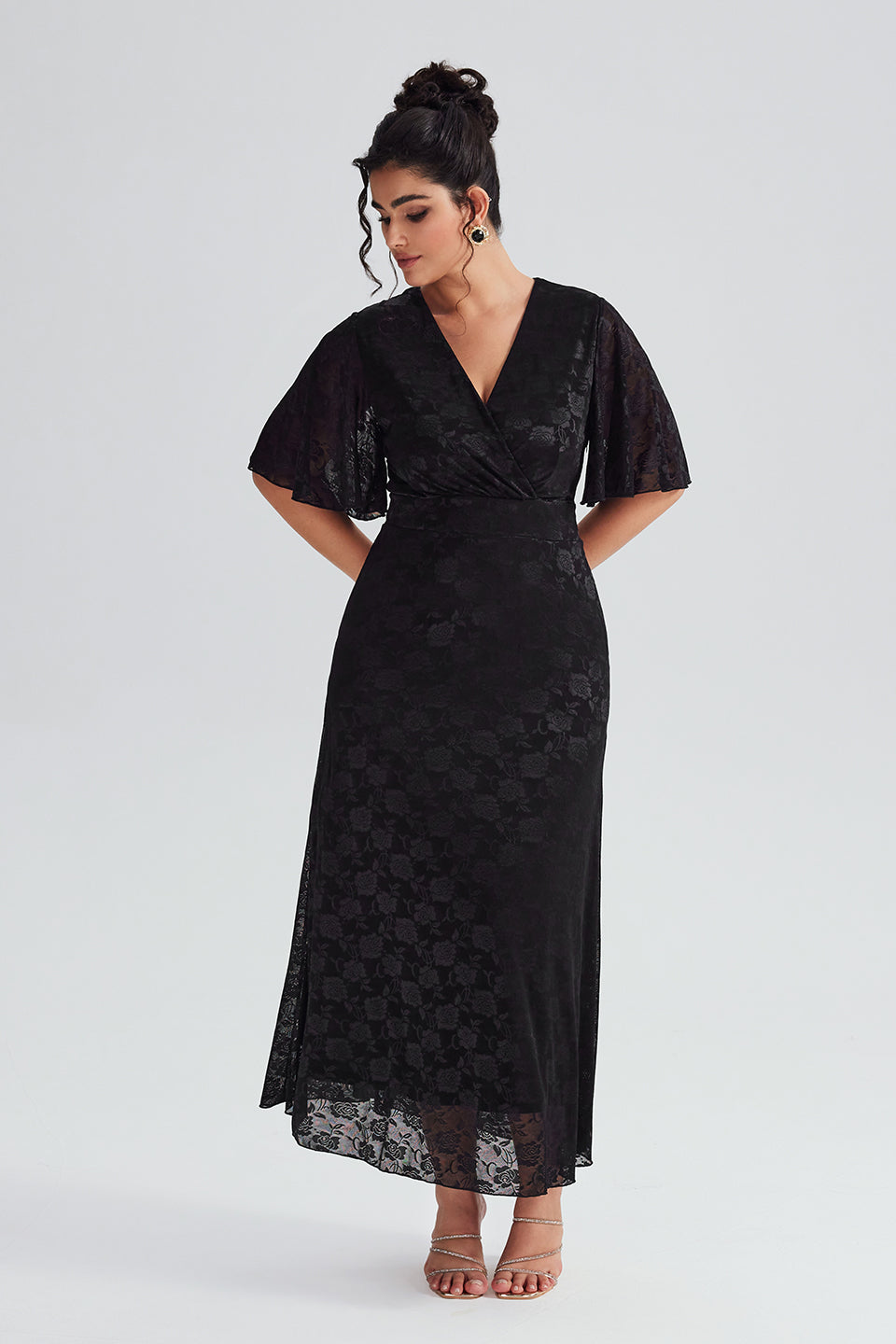 Styled look of a plus-size black lace maxi dress paired with accessories for evening wear, showcasing the versatile styling